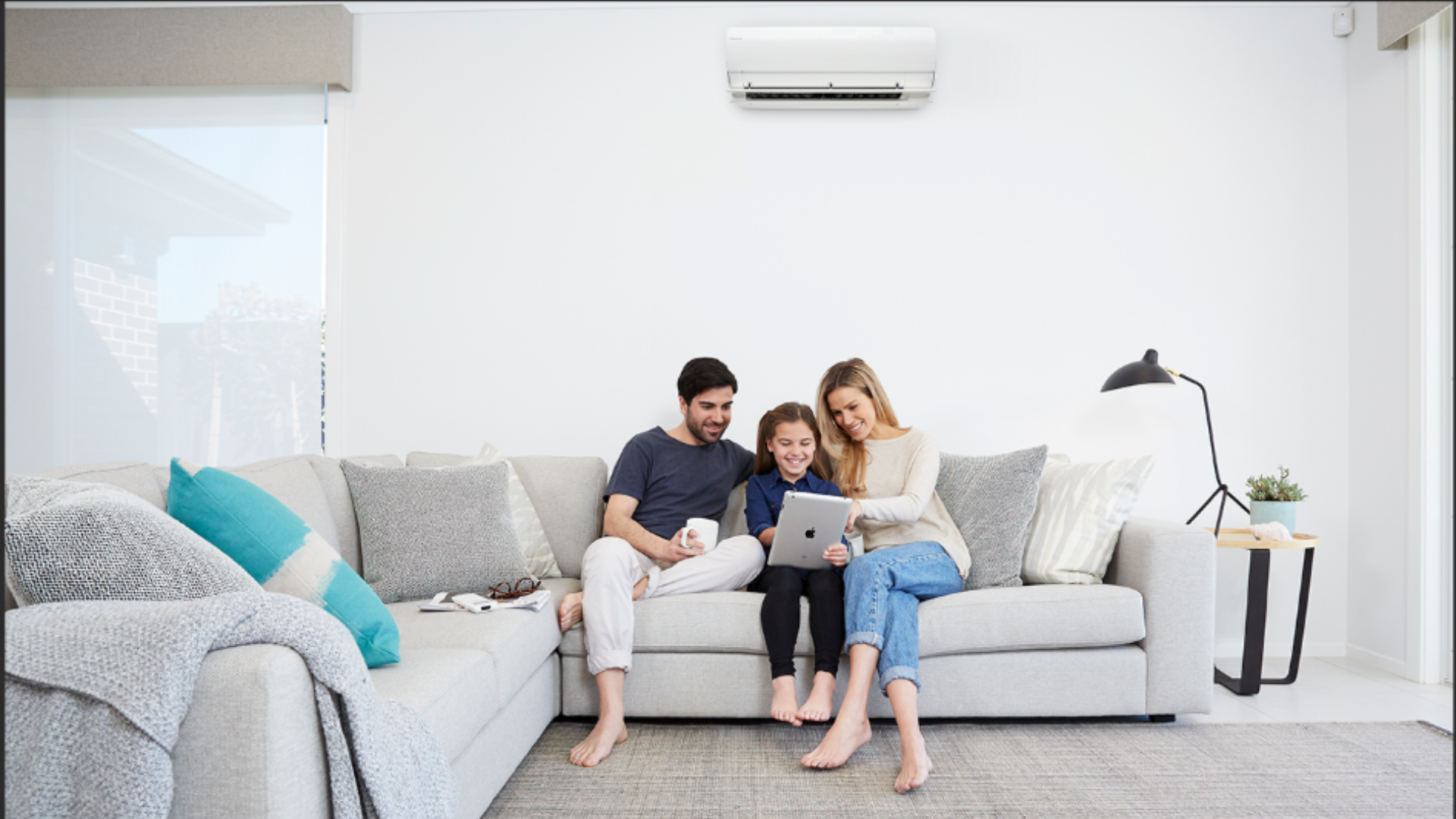 a family of 3 (mother, son and father) in a nice living room with air condition